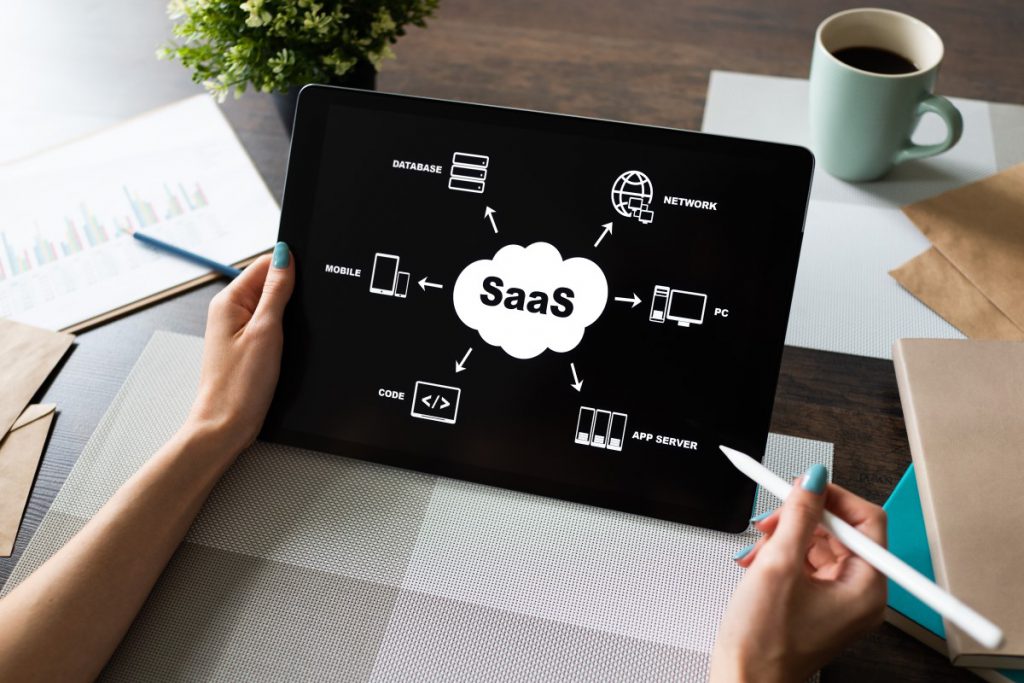 saas（サブスクリプション型ビジネス）と書かれたボードを見ているビジネスマン
